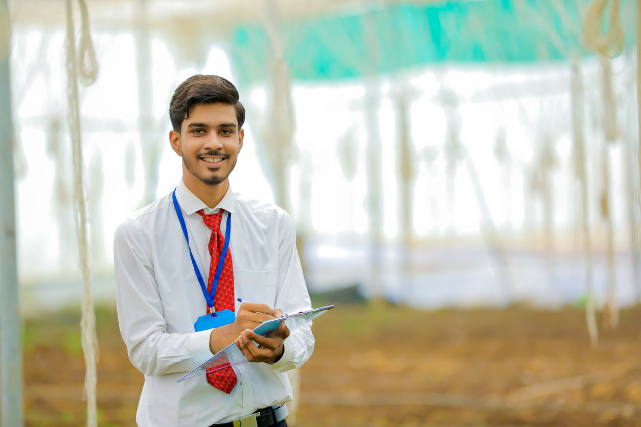 Young Indian agronomist collecting some information at greenhouse