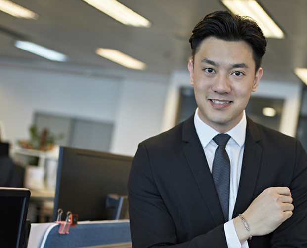 Portrait of young handsome businessman standing at office. Confident male manager is working at corporate office. He is wearing businesswear.